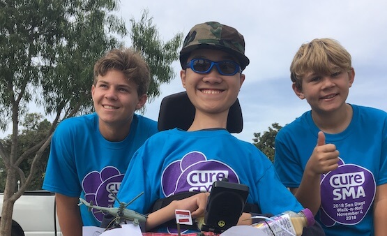 Three smiling boys with cure sma tshirts on